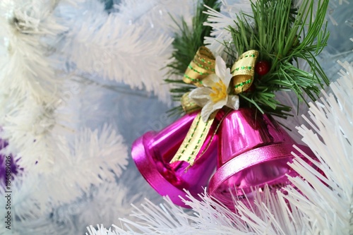 Christmas fir tree with decoration  couple pink jingle bell. Soft focus.