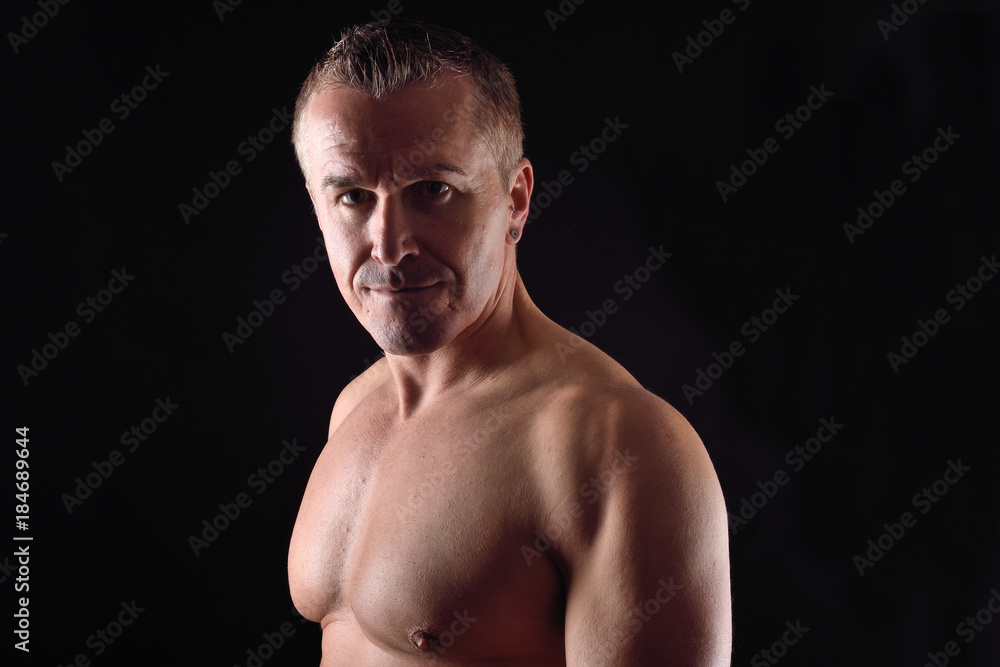 portrait of a man with naked torso on black background portrait of a man with naked torso on black background