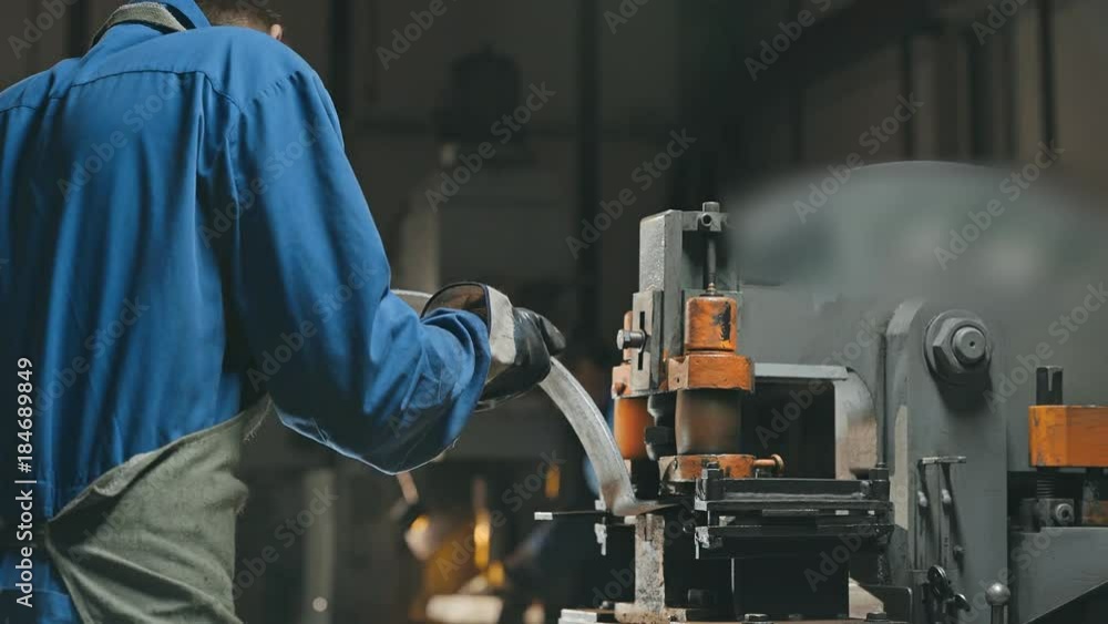 Factory employee using modern cutting lathe for make hole in metalworking detail Factory employee using modern cutting lathe for make hole in metalworking detail