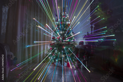 christmas night at home with fireworks effect and rainbow lights christmas tree