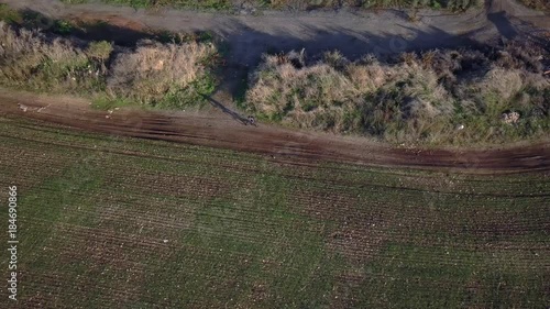 Aerial motion shot of cyclist riding his bicycle along outdoor trail | 4k UHD