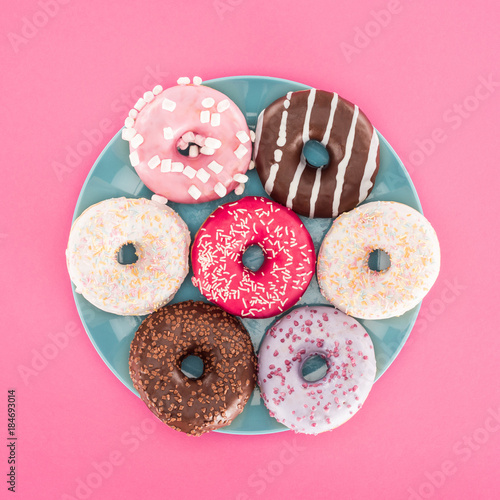 Slika na platnu top view of various glazed doughnuts on plate isolated on pink
