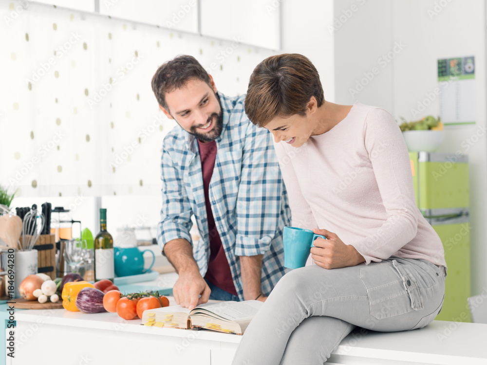 Couple searching recipes on the cookbook Couple searching recipes on the cookbook