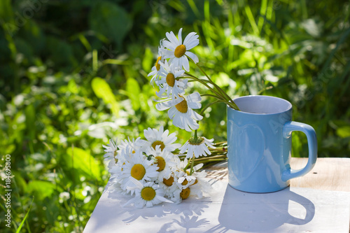 bouquet of wild flowers in cup. Mug with daisies.