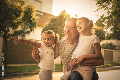 Foto Grandfather with his granddaughters on street looking something fanny