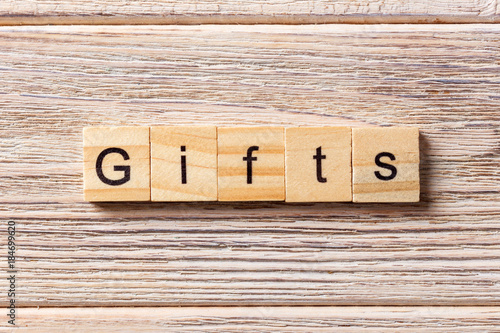 gifts word written on wood block. gifts text on table, concept photo