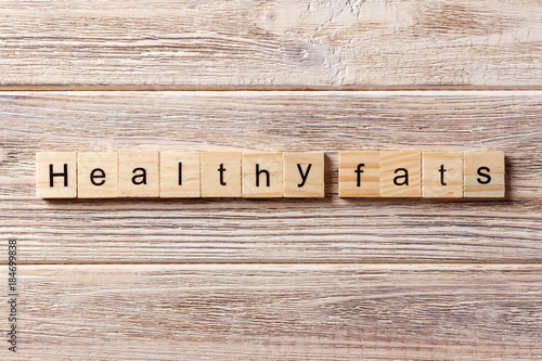 Healthy fats word written on wood block. Healthy fats text on table, concept photo