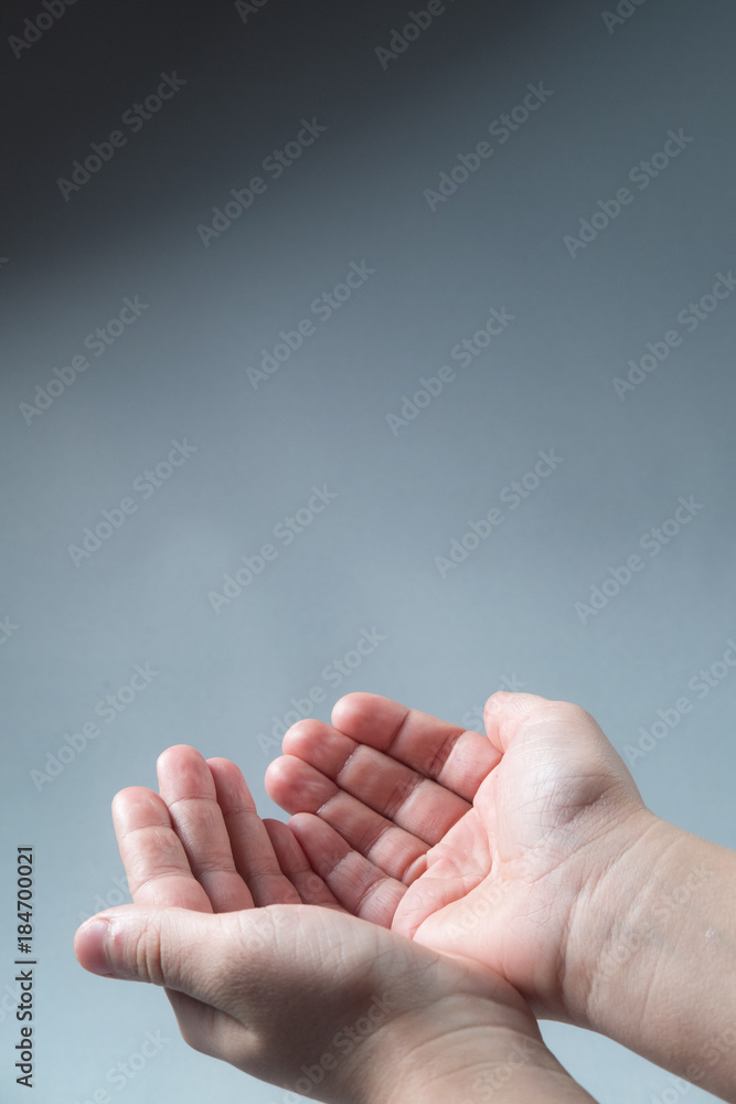 hands folded hands begging alms on a gray background