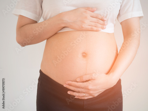 pregnant woman holds her hands on her belly.maternity concept.Belly of pregnant woman with hands. © Surajet.L