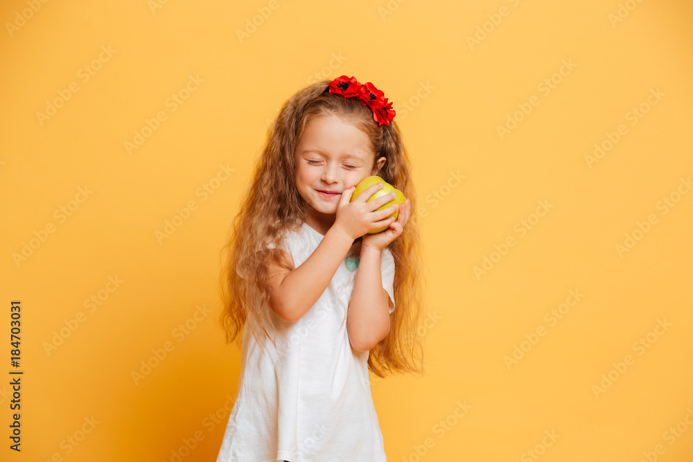 Cheerful little girl child holding apple with eyes closed. Cheerful little girl child holding apple with eyes closed.