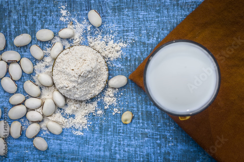 Close up of ayurvedic herb kuanch,cowhage,Mucuna pruriens with powder and milk glass.; photo