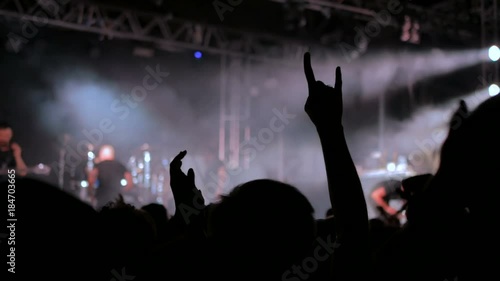 Silhouettes of people partying at rock concert in front of the stage. Strobing stage lighting photo