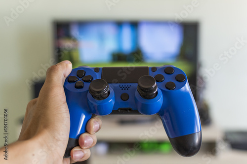 Male hand holding a game joystick controller, front view