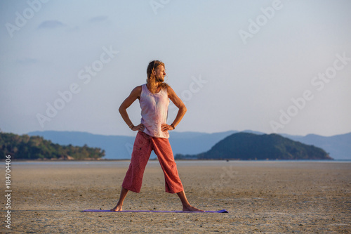 Man is doing yoga on the beach