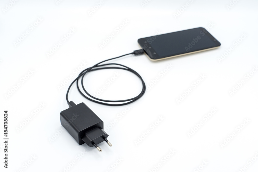 Black AC charger and USB cable connected to mobile phone Black AC charger and USB cable connected to mobile phone