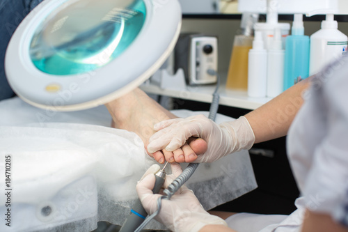 Professional pedicure master making pedicure in salon