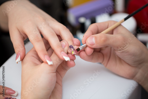 Closeup shot man making manicure to woman in beauty salon