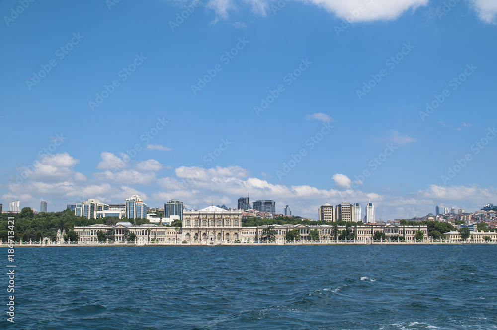 Dolmabahce palace against coastal cityscape with modern buildings under cloudy sky istanbul city Dolmabahce palace against coastal cityscape with modern buildings under cloudy sky istanbul city