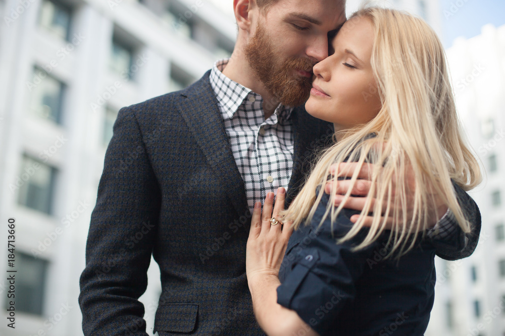 A young man embraces a girl in the city