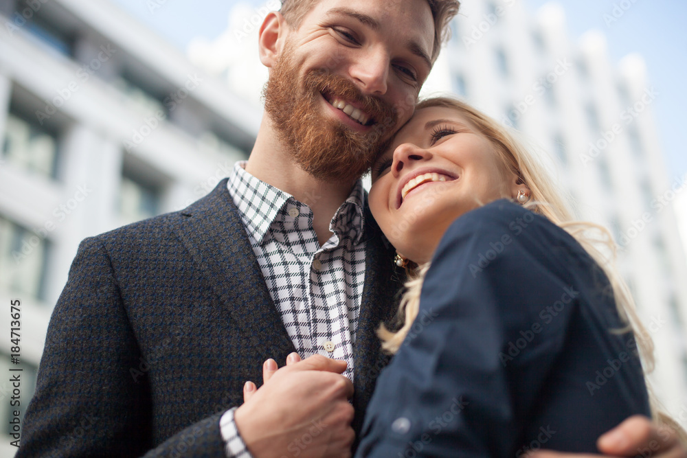 Happy attractive young couple to share a good joke, laughing loudly, embracing each other outdoors in urban environment Happy attractive young couple to share a good joke, laughing loudly, embracing each other outdoors in urban environment