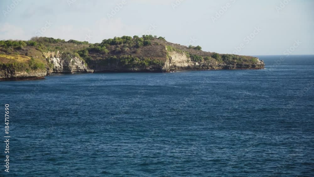 Aerial view of Rocky coast with high cliffs, sea surf with breaking waves on the coast, Nusa Penida, Indonesia. Ocean with waves and rocky cliff. 4K video. Travel concept Aerial footage