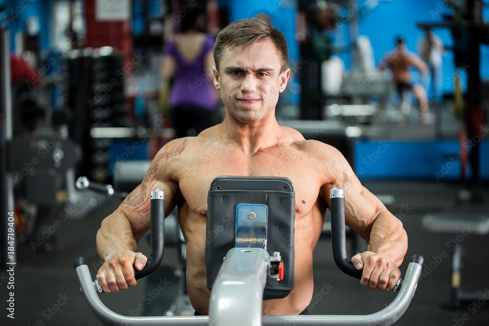 Muscular man working out in gym doing exercises, strong male Muscular man working out in gym doing exercises, strong male