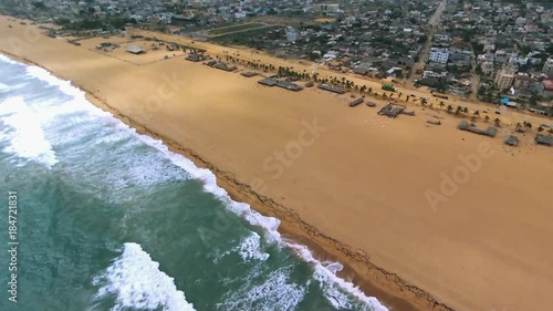 Pan right aerial, waves crash on Cotonou beach photo