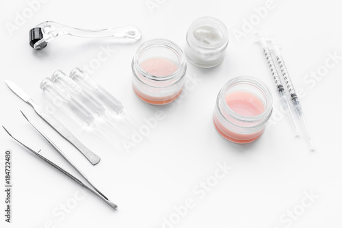 Dermatologist or cosmetologist accessories. Dermaroller, creams and mask, beauty injection, tools on white background copyspace