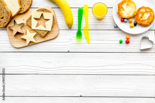Funny breakfast for children. Sandwiches with cheese in shape of star. White wooden background top view copyspace