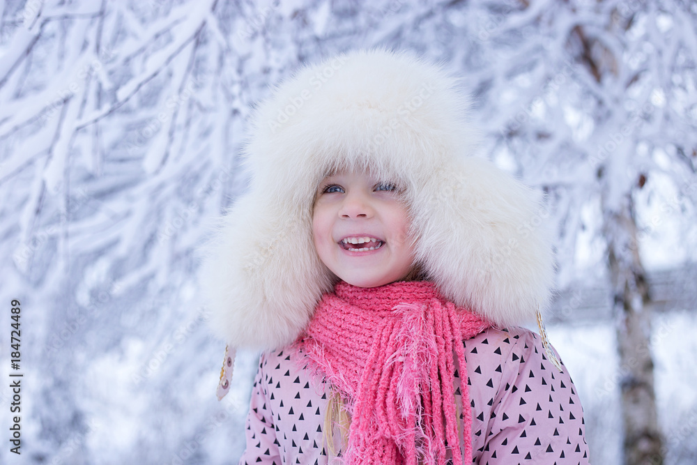 portrait of a girl in the winter with the sun in a fur hat. joyful girl, sunny winter portrait of a girl in the winter with the sun in a fur hat. joyful girl, sunny winter