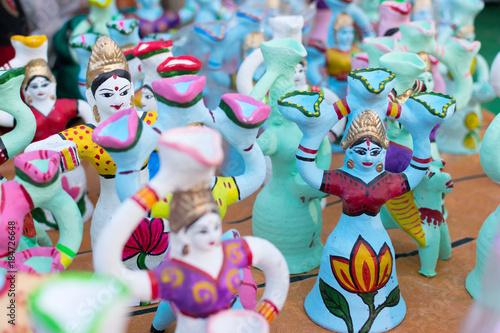 Colorful dolls made of clay, handicrafts on display.