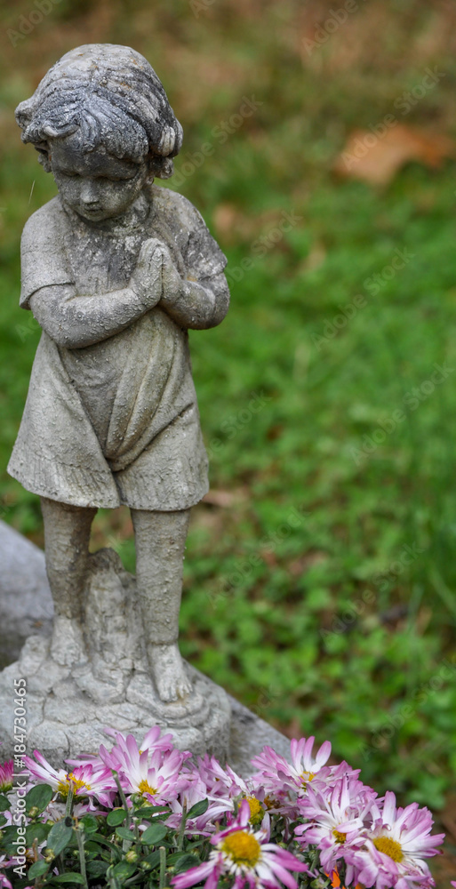 Child Statue in a Graveyard with Flowers Child Statue in a Graveyard with Flowers