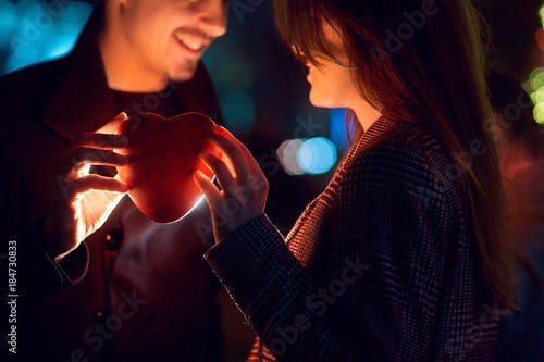 Loving couple with heart in hands outdoors. Concept Valentine s Day.