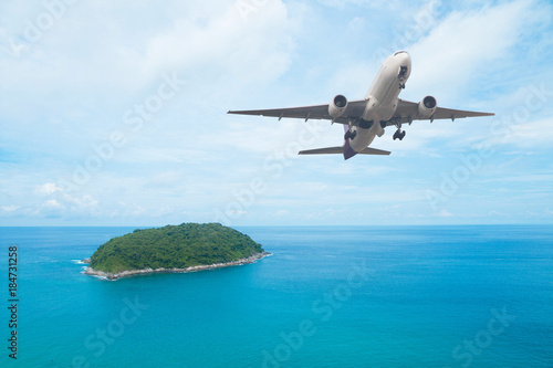 Airplane flying above sea island 