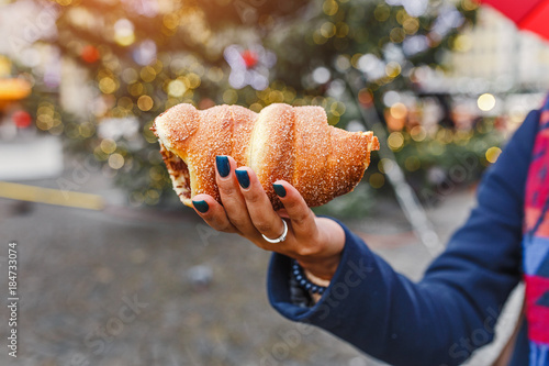 Photography A woman with an appetite eats a traditional sweet pastry of Czech in Prague - a