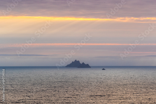 Skellig Michael in County Kerry on the west coast of Ireland in the Atlantic ocean at sunset over a setting sun