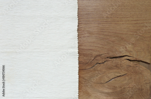 White velvet material from left side wooden table. Striped texture fabric / wood texture. Top view background. photo