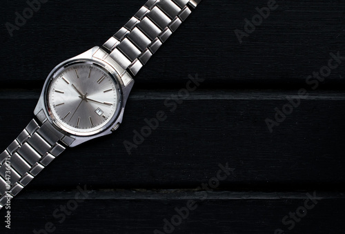 Wallpaper Mural Stainless steel silver mens wrist watch on a black wooden surface, with lots of copy space and contrast Torontodigital.ca