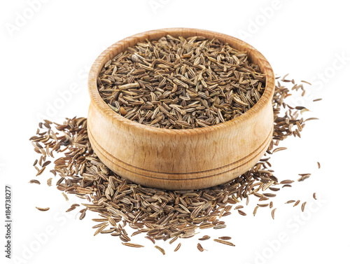 Cumin or caraway seeds in wooden bowl isolated on white background
