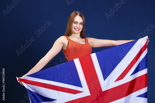 Happy young woman holding a flag of of Great Britain (British flag)