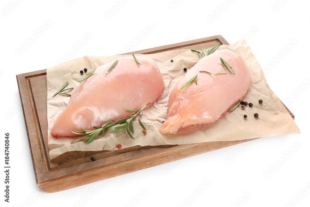 Wooden board with raw chicken fillet on white background