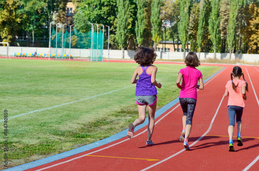 Family sport and fitness, happy mother and kids running on stadium track outdoors, children healthy active  lifestyle concept
