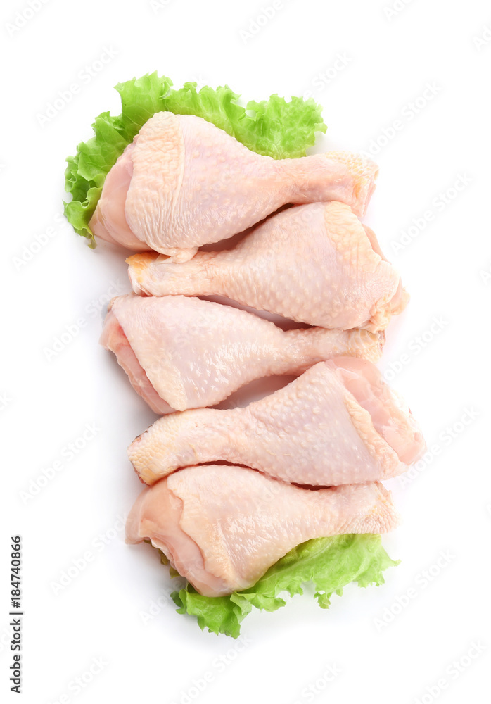 Raw chicken legs with lettuce on white background Raw chicken legs with lettuce on white background
