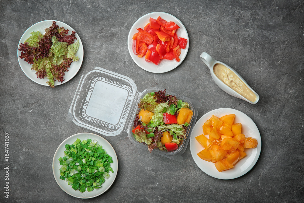 Flat lay composition with salad and ingredients on grey background