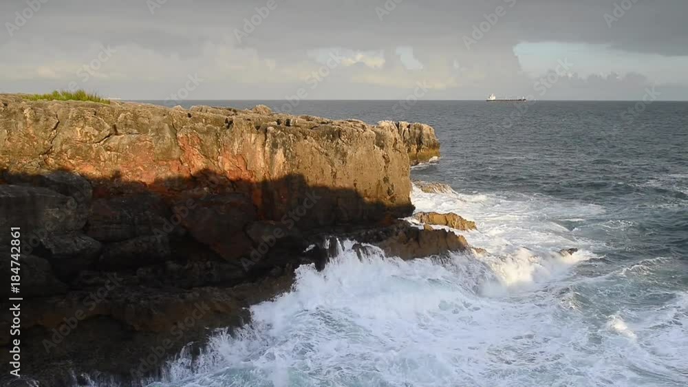 Detailed view of volcanic coastline with high cliffs and waves breaking over volcanic rocks, Portugal. Detailed view of volcanic coastline with high cliffs and waves breaking over volcanic rocks, Portugal.