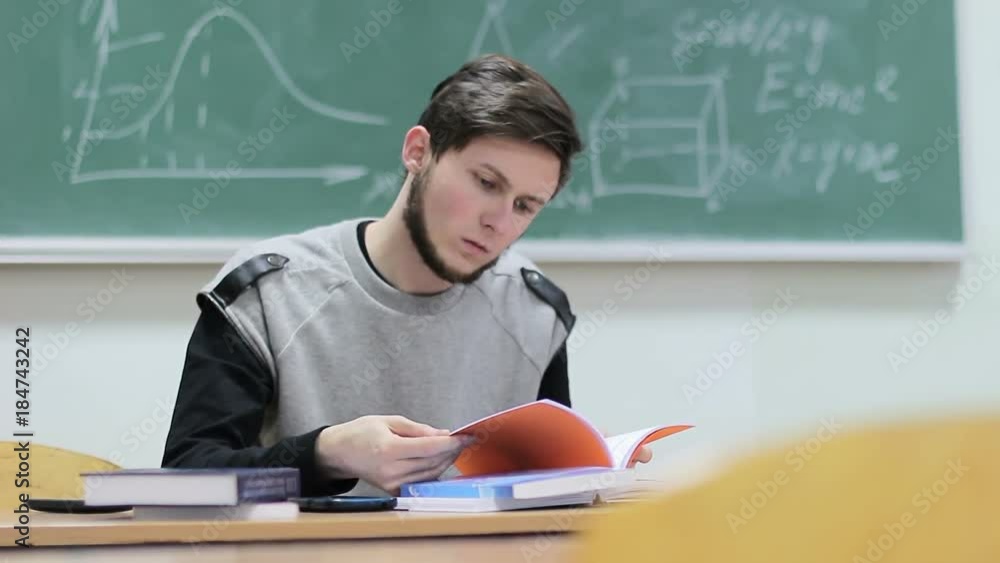 Student sitting at a desk with textbooks and notebooks in class Student sitting at a desk with textbooks and notebooks in class