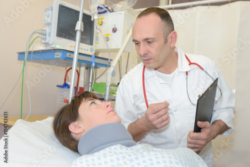 doctor talking to female patient in hospital room