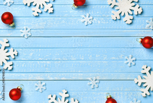 Holiday postcard frame. Christmas wooden decorations of snowflakes, horses, red glass balls on a background of blue vintage old wooden boards. Background for your text and design
