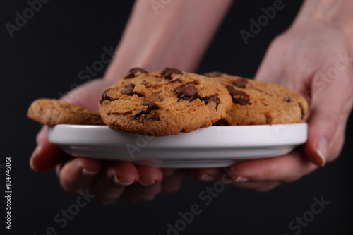 Woman holding plate with Christmas chocolate chip cookies close up. Baking at home concept