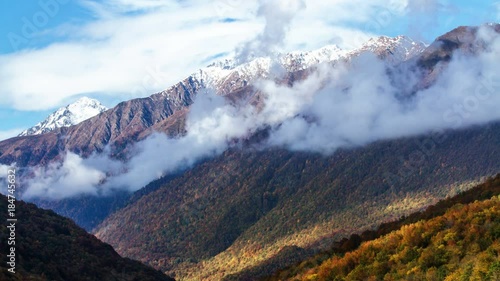 Cloudy mountains landscape with autumn forest at sunset. Time lapse. Sochi, Russia